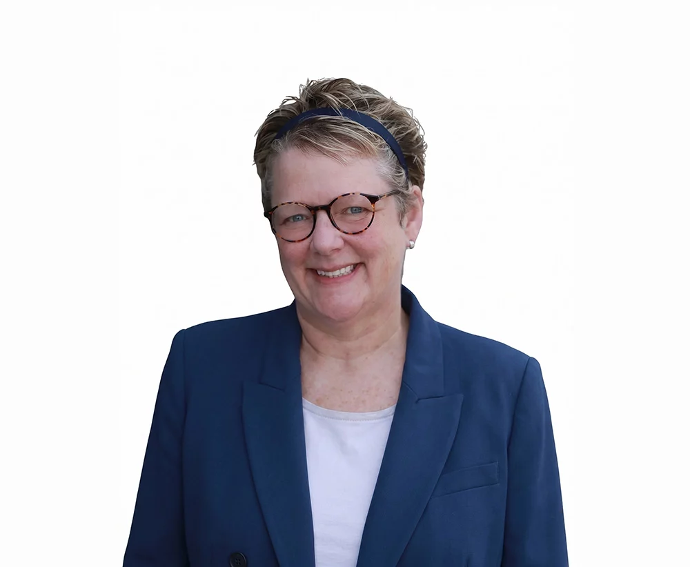 Heather Fogg smiling in a navy blazer and tortoiseshell glasses