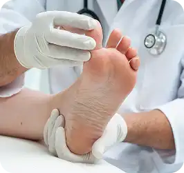 Gloved nurse examining the sole of a patient's foot